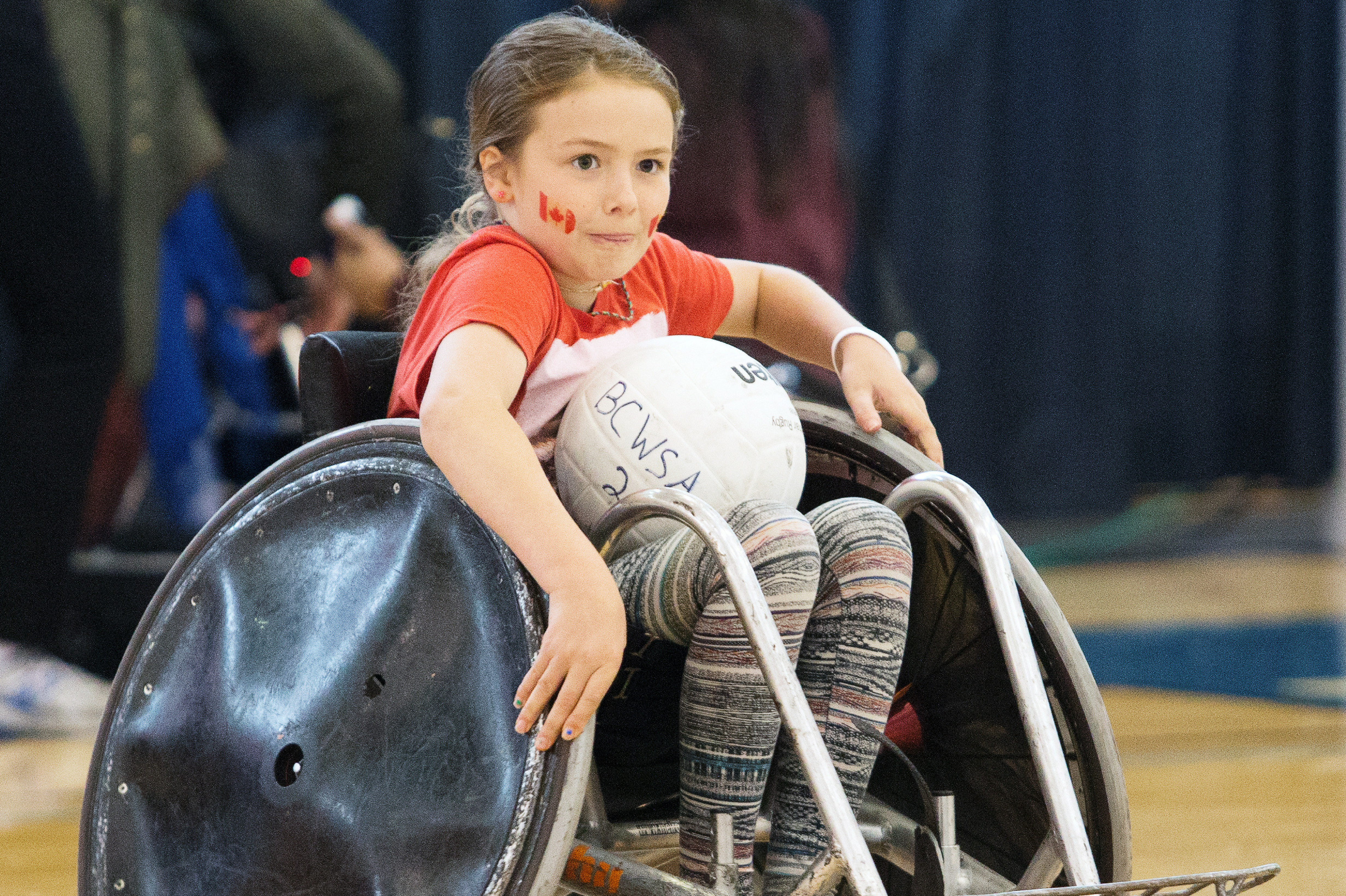 a young girl wheelchair rugby player with a warrior like look on her face